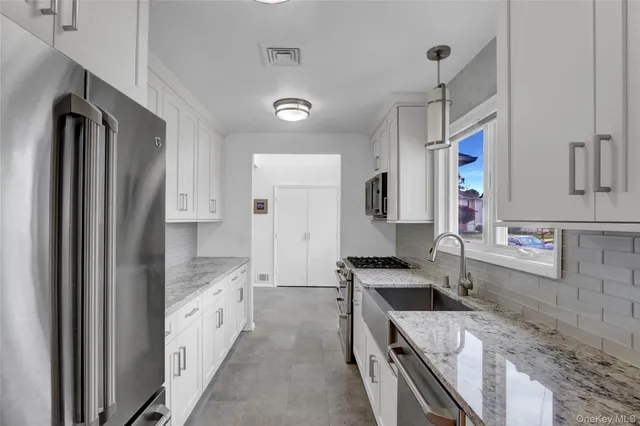 a kitchen with stainless steel appliances granite countertop a sink stove and refrigerator