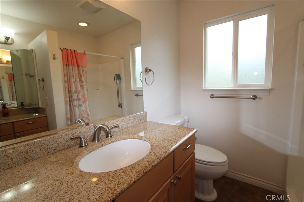 3085 Gardner Road Nice, CA 95464 - Photo 17 of 20 a bathroom with a granite countertop sink toilet and mirror