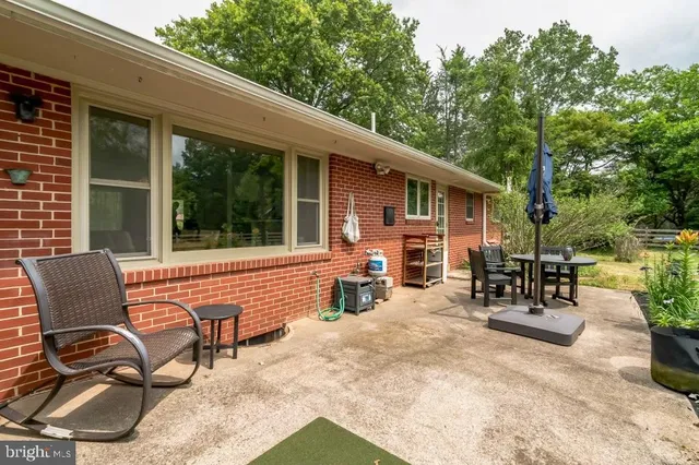 a view of backyard with outdoor seating and trees