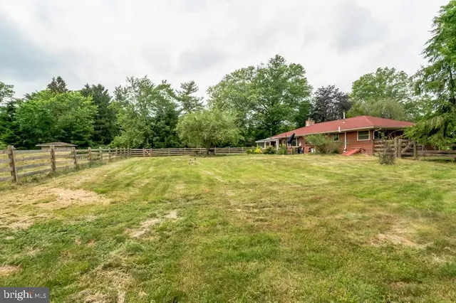 a view of a swimming pool with an outdoor seating and house in the background