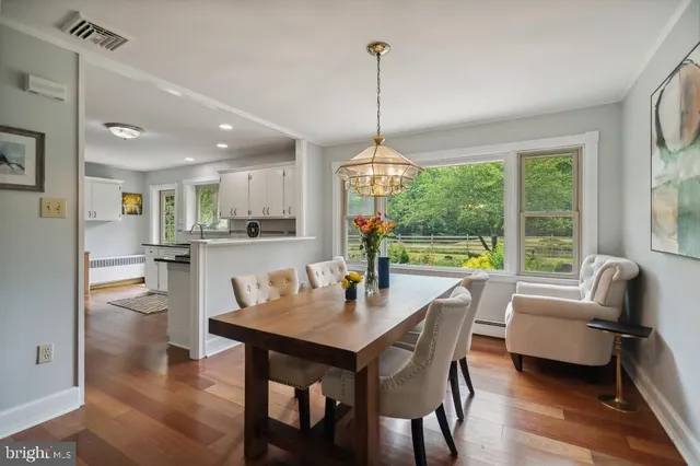 a dining room with furniture a chandelier and wooden floor