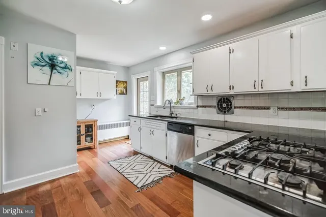 a kitchen with white cabinets and appliances