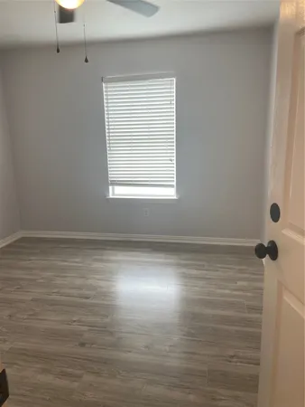 a view of a room with wooden floor and window