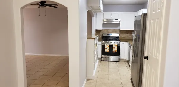 a kitchen with stainless steel appliances granite countertop a refrigerator and a stove