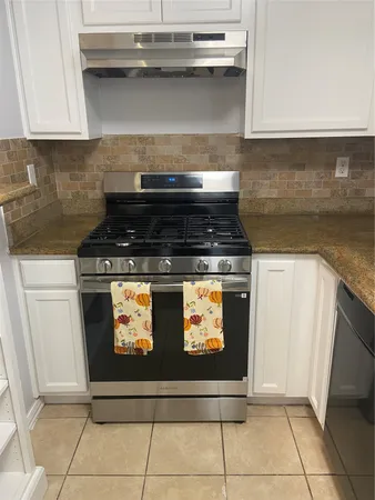 a stove top oven sitting inside of a kitchen