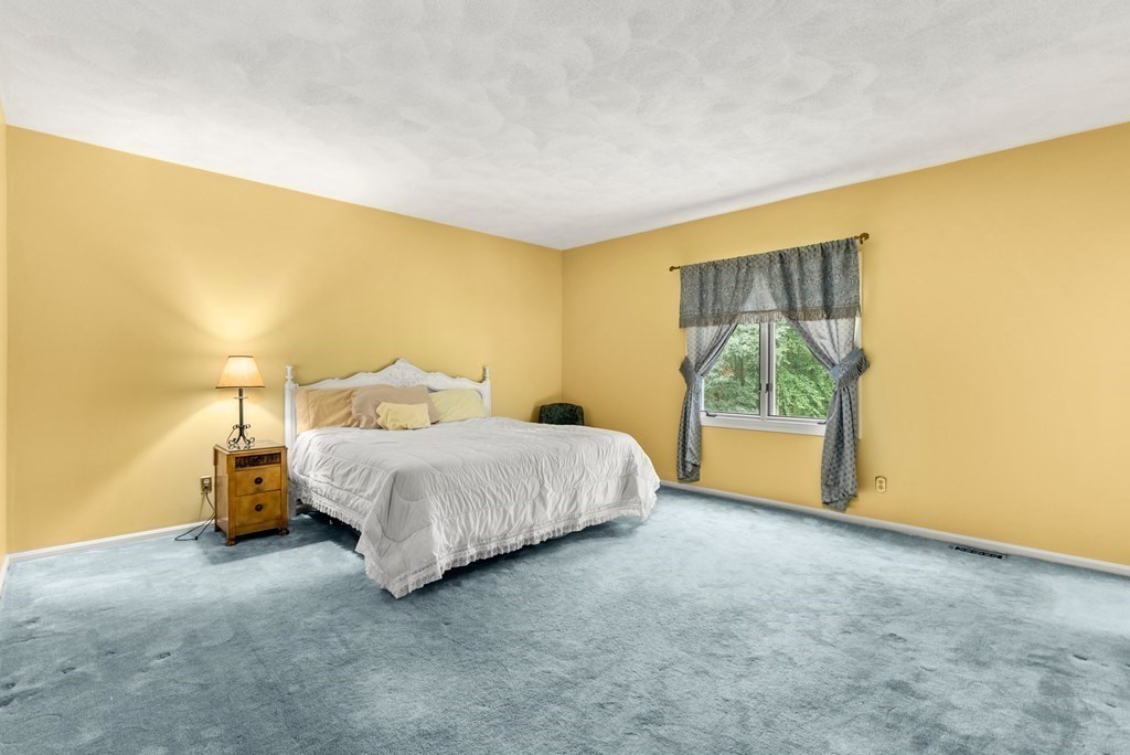 26 Fox Run Road Sudbury, MA 01776 - Photo 18 of 42 a spacious bedroom with a bed and wooden floor