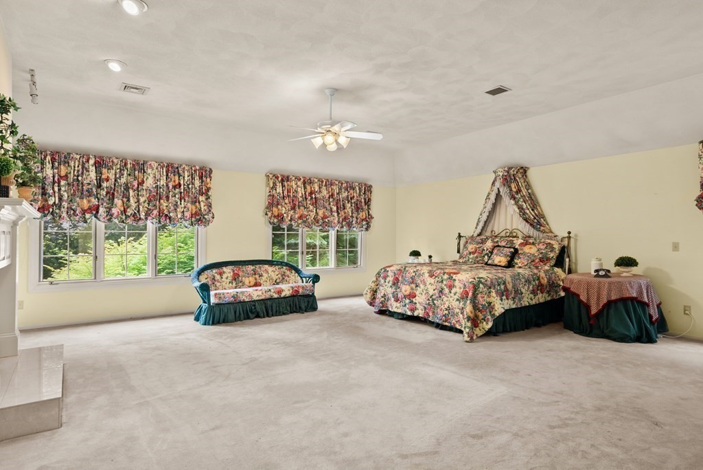 26 Fox Run Road Sudbury, MA 01776 - Photo 21 of 42 a bedroom with a bed and a chandelier