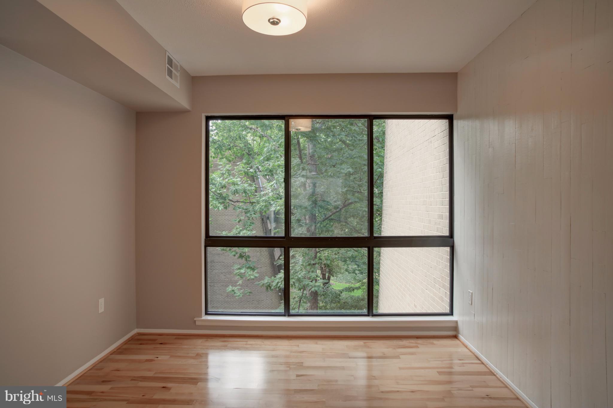 11616 Ivystone Court, Unit 301 Reston, VA 20191 - Photo 7 of 29 an empty room with wooden floor and windows