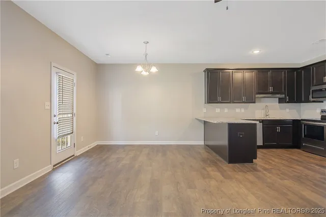 a large kitchen with kitchen island granite countertop a wooden cabinets and a granite counter tops