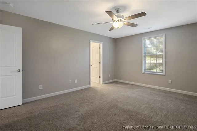 an empty room with ceiling fan and window