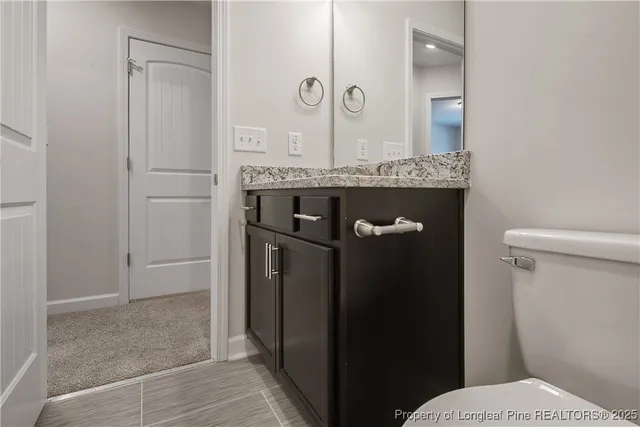 a bathroom with a granite countertop shower a toilet and a sink