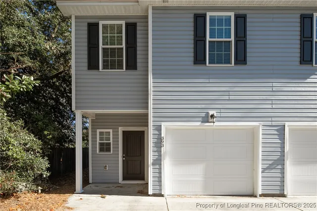 a view of a house with a door and a tree