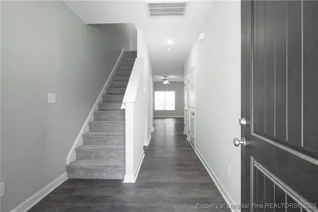 a view of a hallway with wooden floor and stairs