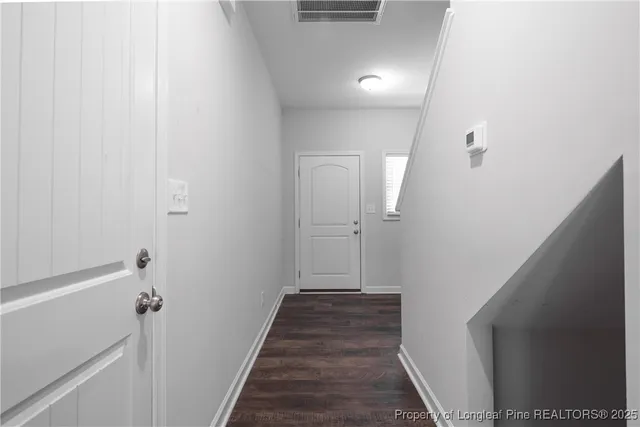 a view of a hallway with wooden floor and staircase