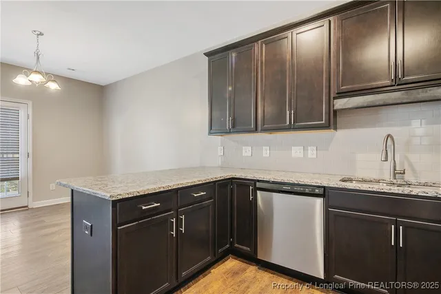 a kitchen with granite countertop stainless steel appliances a sink stove and cabinets