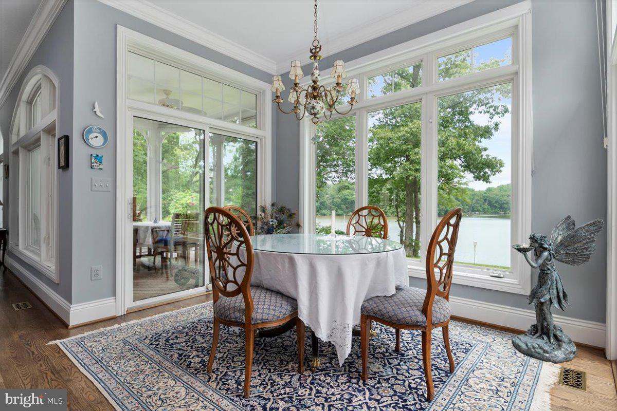 3332 Breckenridge Way Riva, MD 21140 - Photo 18 of 50 a dining room with furniture wooden floor a rug a potted plant and a chandelier