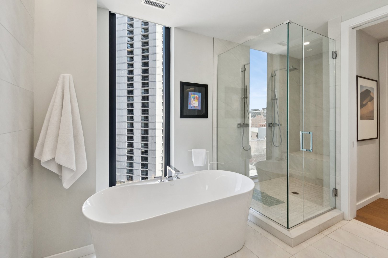 56 West Huron Street, Unit 9 Chicago, IL 60654 - Photo 26 of 38 a bathroom with a tub a sink and glass door shower