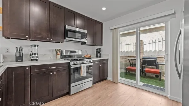 a kitchen with stainless steel appliances granite countertop a stove a sink and a microwave