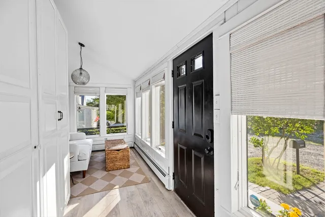 a view of a hallway with wooden floor and a livingroom