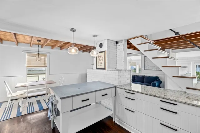 a kitchen with a table chairs and white cabinets