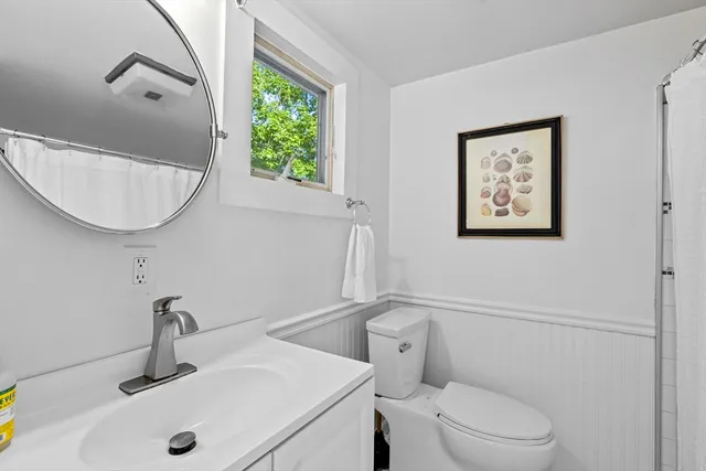 a bathroom with a toilet a sink and mirror