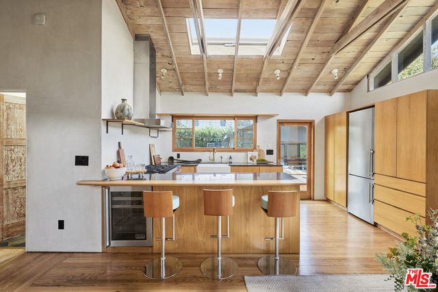 a kitchen with kitchen island granite countertop wooden cabinets and white appliances