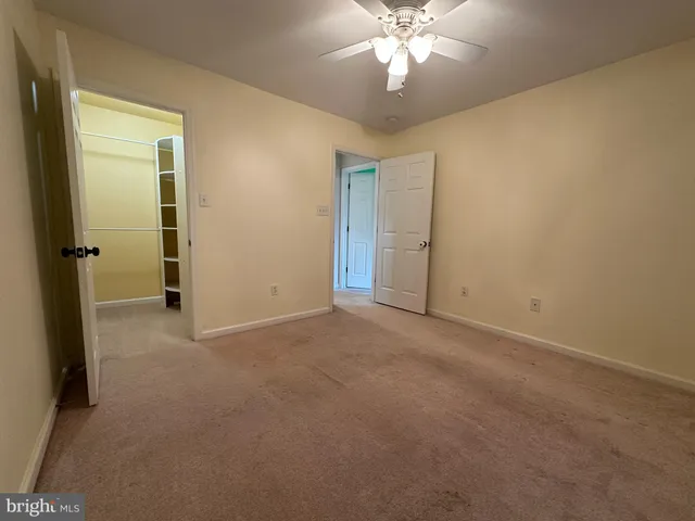 an empty room with a view of a chandelier fan