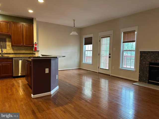 a kitchen with stainless steel appliances granite countertop a stove top oven and a wooden floors