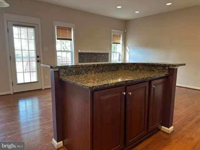 an empty room with wooden floor and window