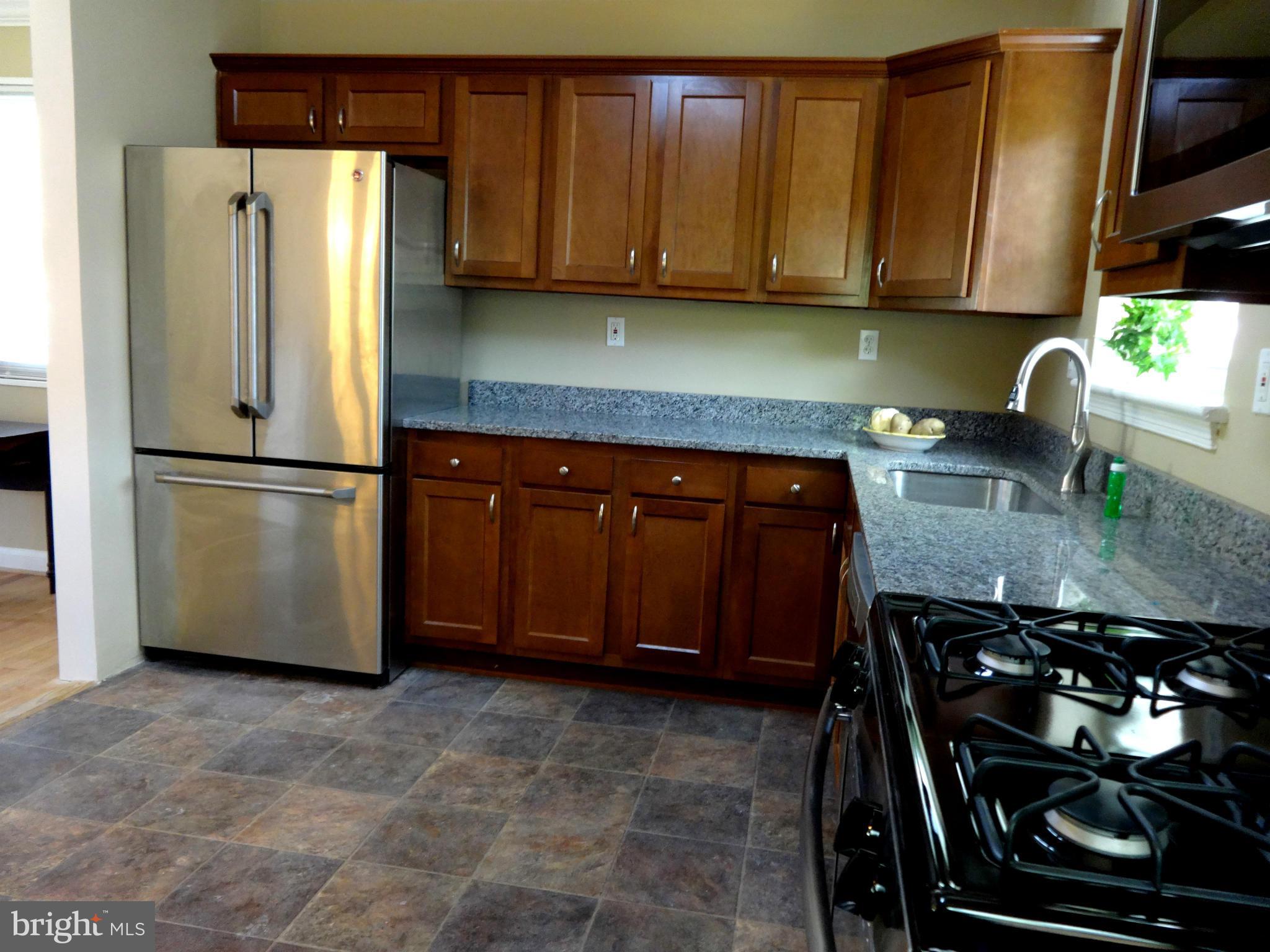 502 Royalton Road Silver Spring, MD 20901 - Photo 8 of 22 a kitchen with stainless steel appliances granite countertop a refrigerator stove and sink