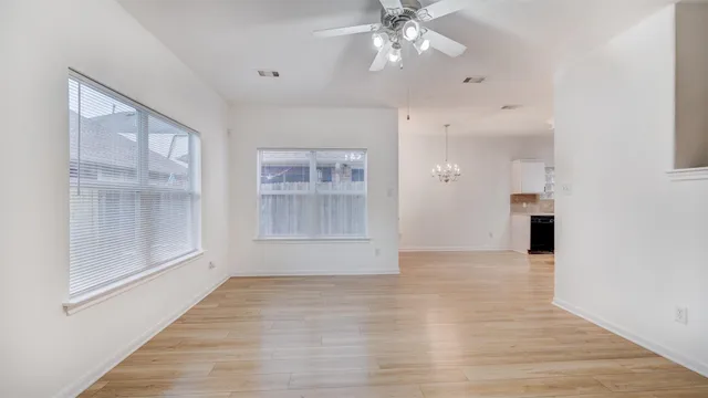 a view of a room with wooden floor and chandelier
