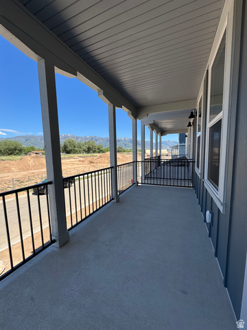 1476 North 1875 West, Unit 152 Layton, UT 84041 - Photo 10 of 20 Covered outdoor balcony featuring mountain scenery, concrete flooring, black metal railings, and attached exterior lighting