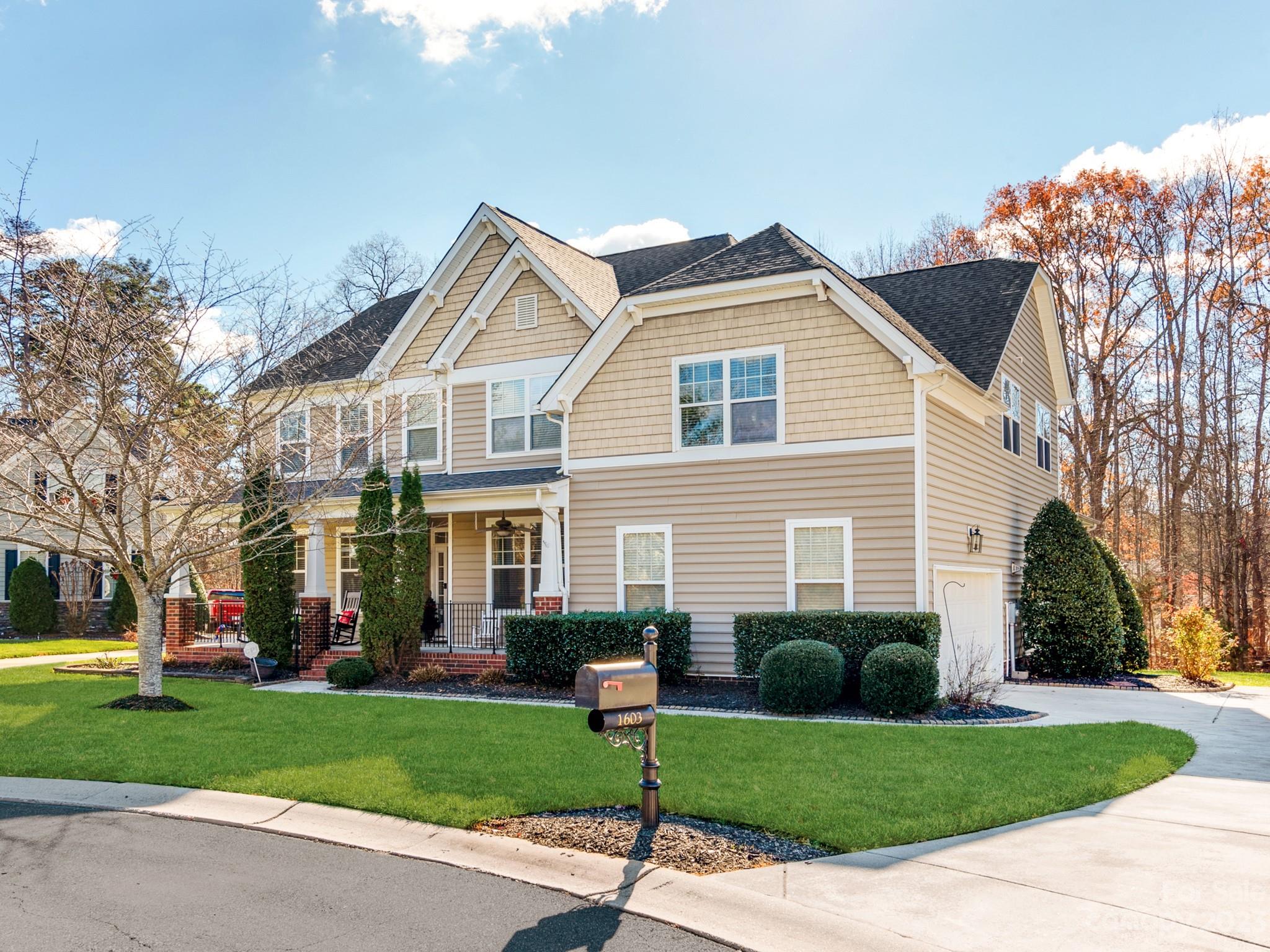 a front view of a house with a garden and trees