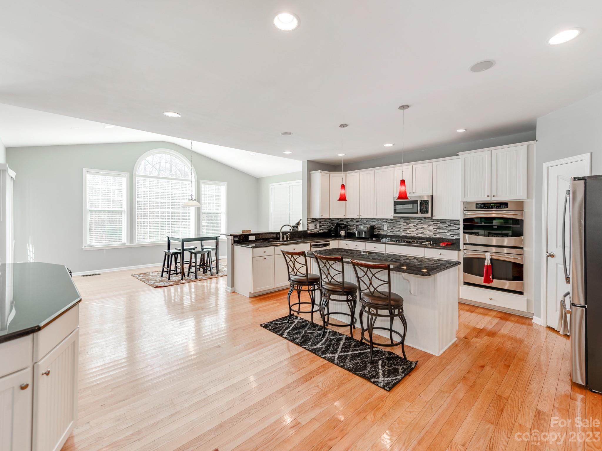 1603 Randwick Way Matthews, NC 28104 - Photo 17 of 48 a kitchen with stainless steel appliances a dining table chairs stove and cabinets