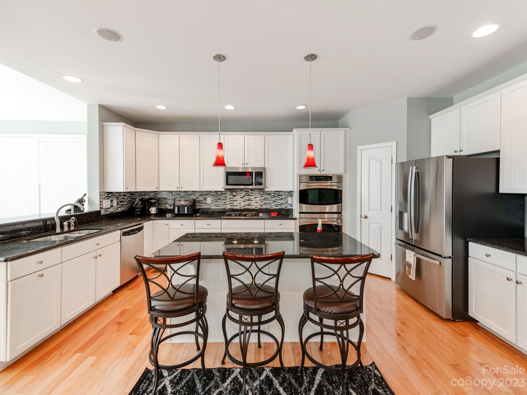 1603 Randwick Way Matthews, NC 28104 - Photo 19 of 48 a kitchen with stainless steel appliances granite countertop a table and chairs in it