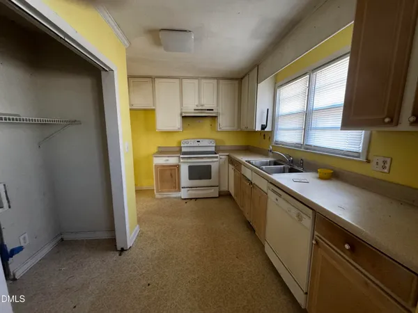 a kitchen with a sink cabinets stainless steel appliances and a window