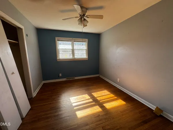 a view of empty room with wooden floor