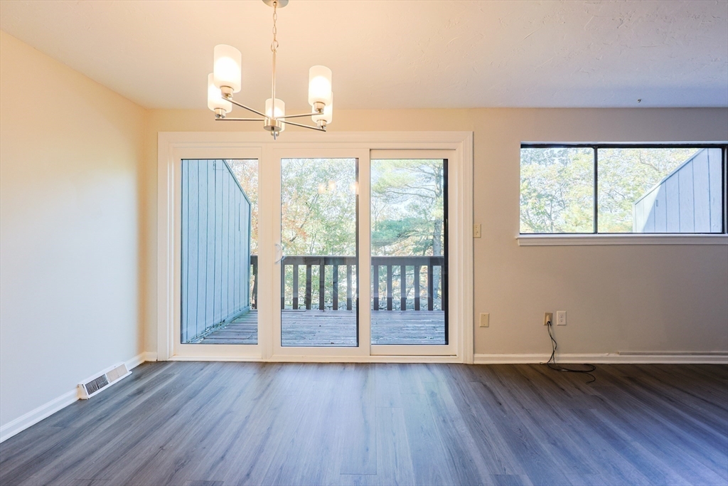 63 Trailside Way, Unit 63 Ashland, MA 01721 - Photo 11 of 39 an empty room with wooden floor and windows