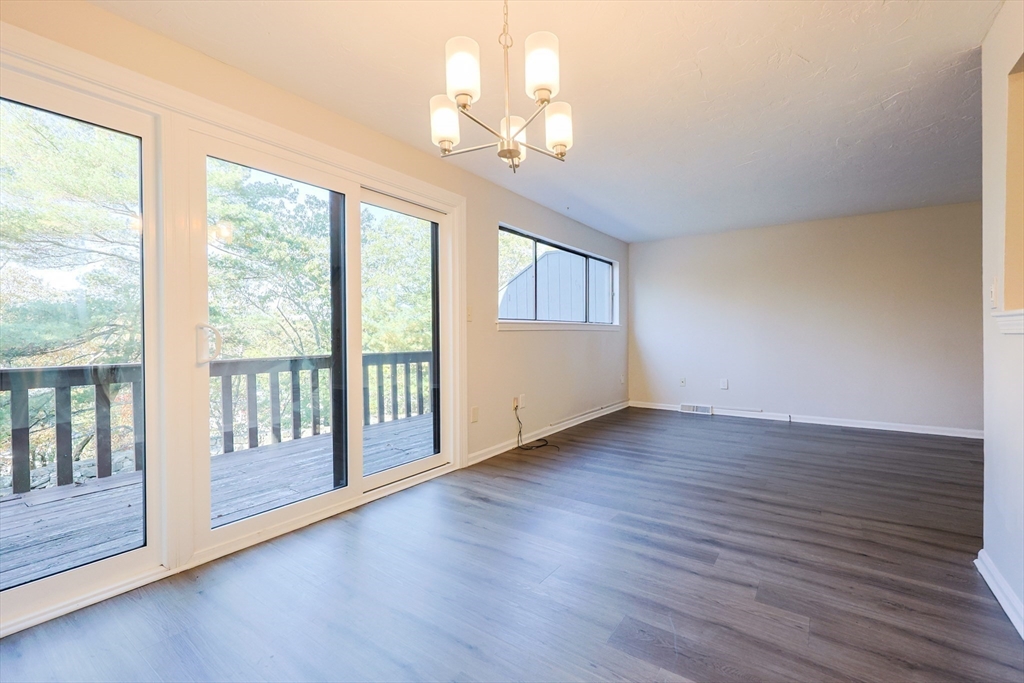 63 Trailside Way, Unit 63 Ashland, MA 01721 - Photo 12 of 39 a view of an empty room with wooden floor and a window