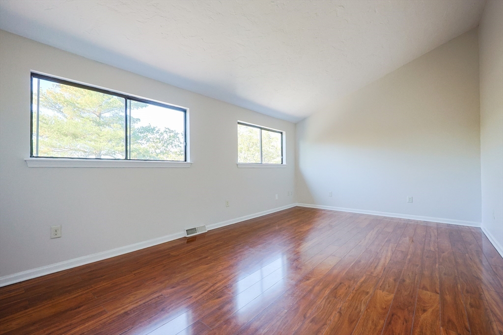 63 Trailside Way, Unit 63 Ashland, MA 01721 - Photo 20 of 39 a view of an empty room with wooden floor and a window