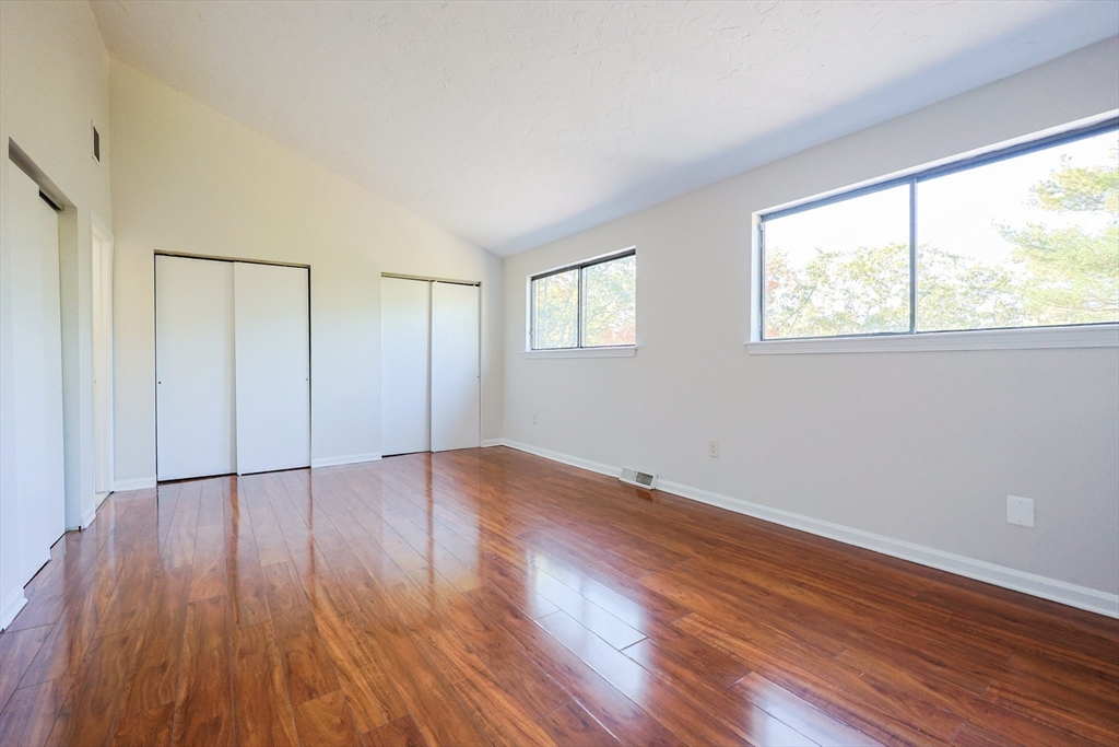 63 Trailside Way, Unit 63 Ashland, MA 01721 - Photo 21 of 39 a view of an empty room with wooden floor and a window