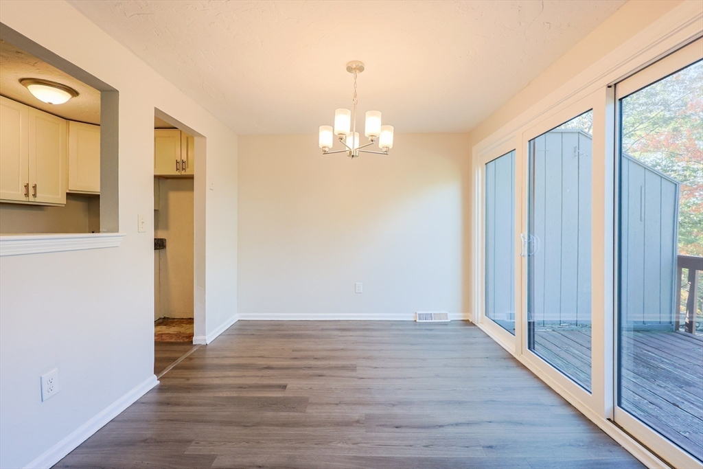 63 Trailside Way, Unit 63 Ashland, MA 01721 - Photo 7 of 39 a view of a hallway with wooden floor and a chandelier