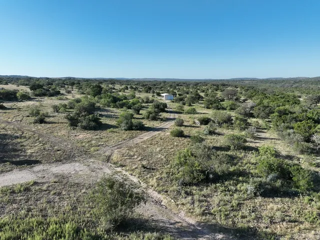 an aerial view of residential houses with outdoor space and trees
