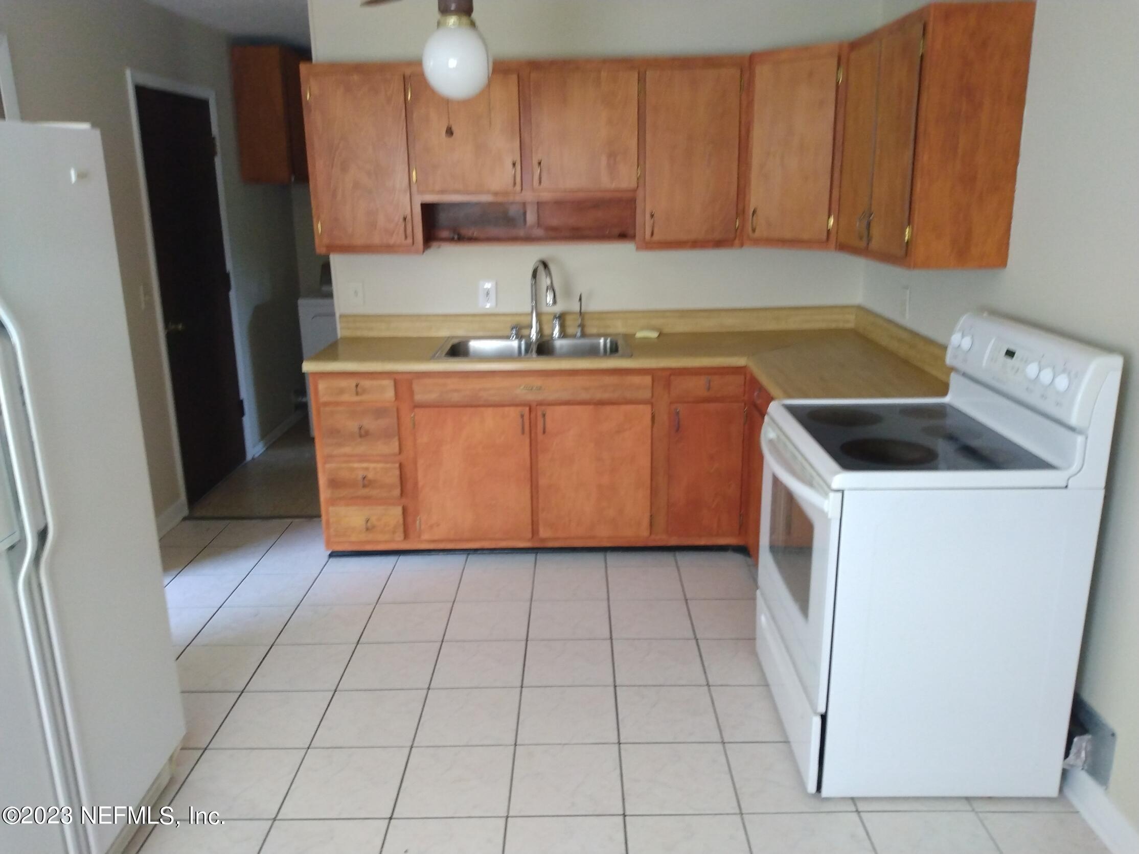 710 Redfin Drive Atlantic Beach, FL 32233 - Photo 17 of 38 a kitchen with a sink a refrigerator and cabinets