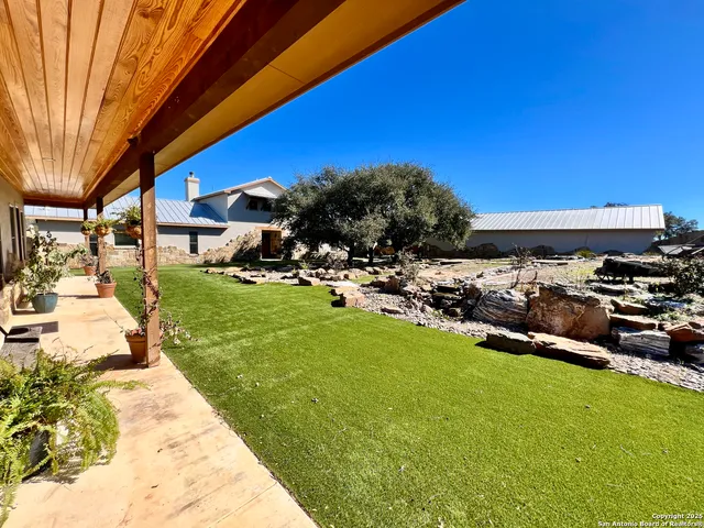 a view of a backyard with table and chairs under an umbrella