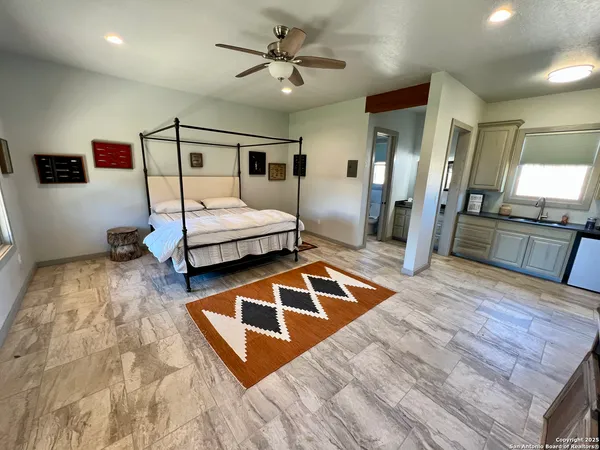 a bedroom with a bed and a view of living room