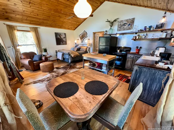 a living room with furniture a flat screen tv and kitchen view