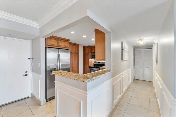 a kitchen with stainless steel appliances kitchen island granite countertop a refrigerator and a sink