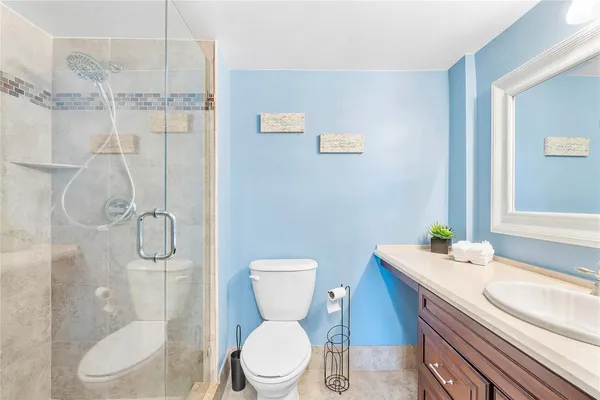 a bathroom with a granite countertop toilet sink and shower