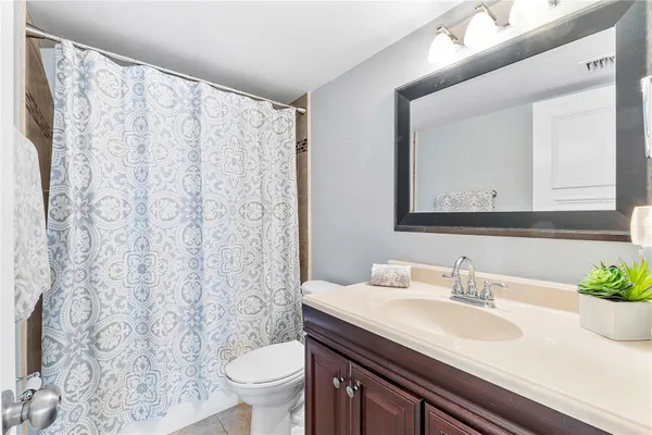 a bathroom with a granite countertop sink a toilet and a mirror